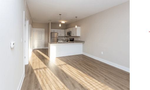 A kitchen with wooden floors and white walls.