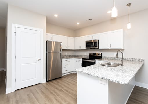A kitchen with a granite countertop and stainless steel appliances.