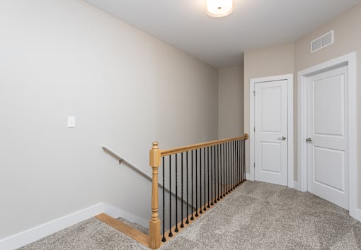 A room with a staircase and two doors.