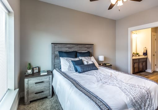 A bedroom with a large bed and a ceiling fan.