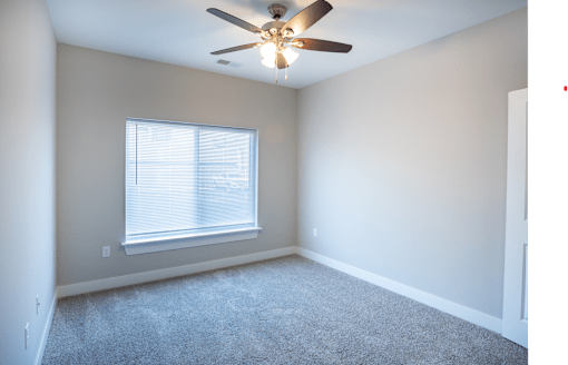 A room with a ceiling fan and a window.
