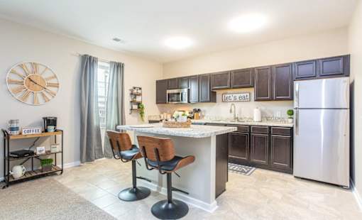A kitchen with a bar area and a clock on the wall.
