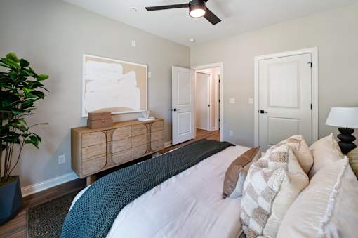 A bedroom with a large bed and a ceiling fan.