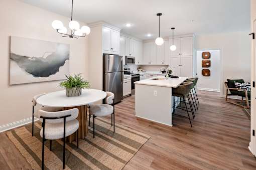A modern kitchen with a dining table and chairs.