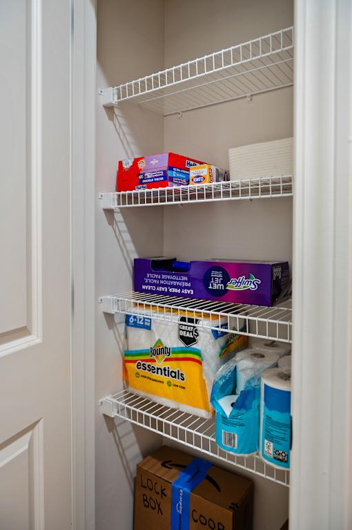 A white refrigerator is open and has a box of essentials, a box of Coors, and a box of milk on the shelves.