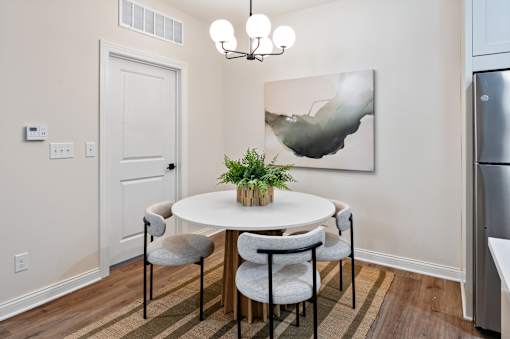 A dining room with a white table and chairs.