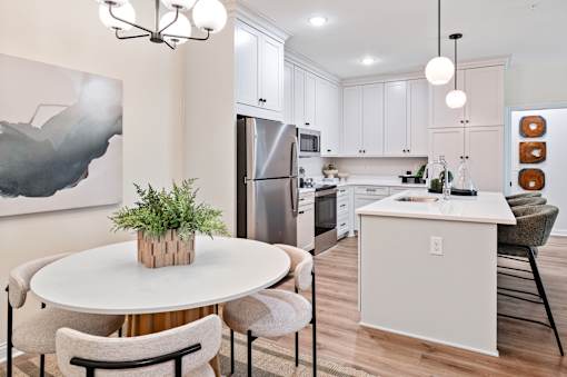 A modern kitchen with a dining table and chairs.