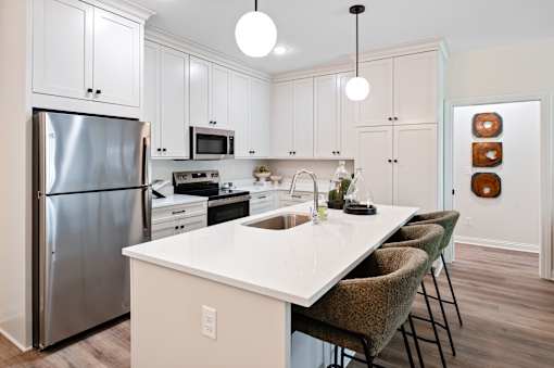 A kitchen with a white island and a refrigerator.