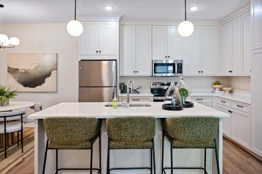 A modern kitchen with a white table and chairs.