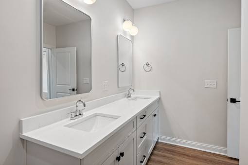 A white bathroom with a sink and mirror.