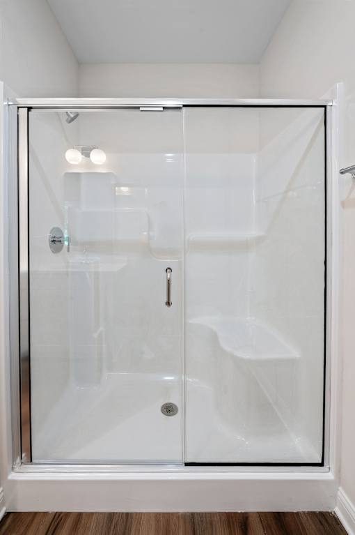 A white bathroom with a glass shower door.
