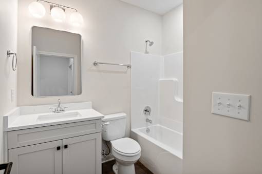 A white bathroom with a sink, toilet, and bathtub.