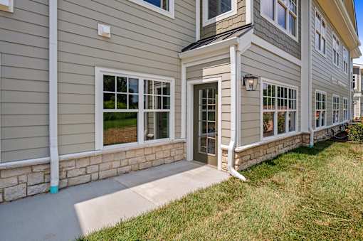 A house with a grey siding and a white door.