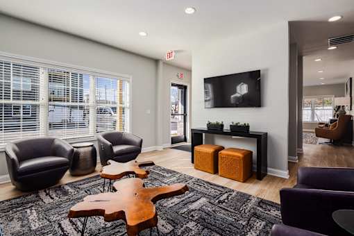 A modern waiting room with a flat screen TV and comfortable seating.