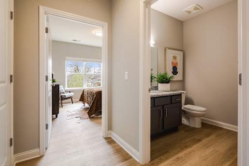 A bathroom with a toilet, sink, and a painting on the wall.