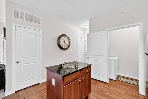 A room with a wooden cabinet and a clock on the wall.