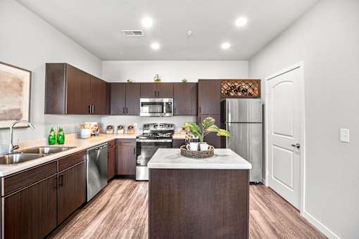 A kitchen with brown cabinets and a white island.