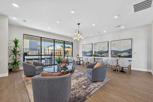 A modern living room with a large grey sofa and a glass table.