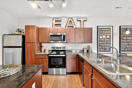 A kitchen with wooden cabinets and a stainless steel refrigerator.