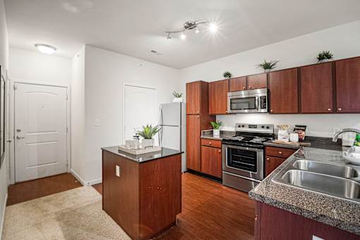 A kitchen with wooden cabinets and a granite countertop. at Aventura at Richmond, St. Peters, 63376