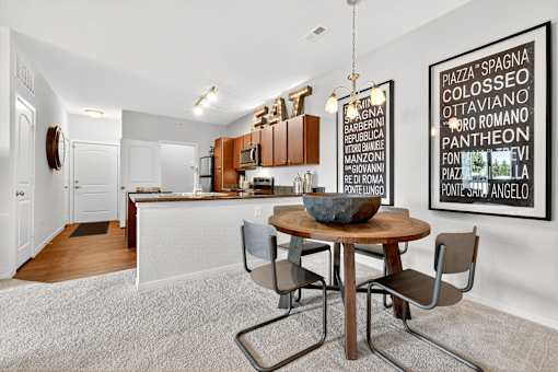 A modern kitchen with a dining table and chairs.
