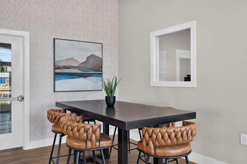 A dining table with four chairs and a potted plant.