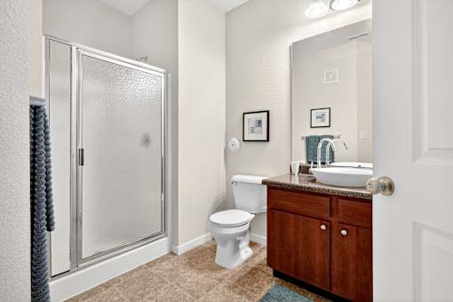 A bathroom with a toilet, sink, and shower.