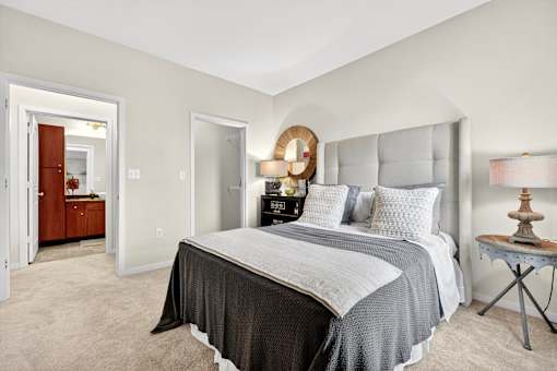 A bedroom with a large bed and a dresser with a mirror.