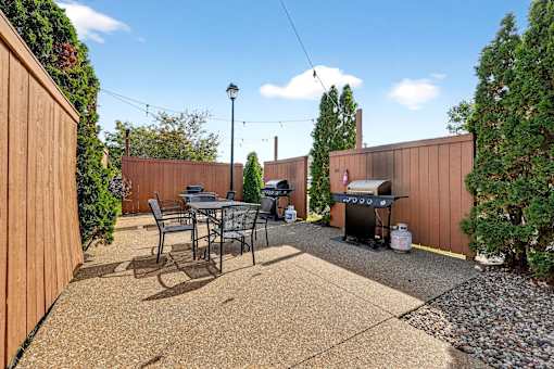 A backyard with a table and chairs.