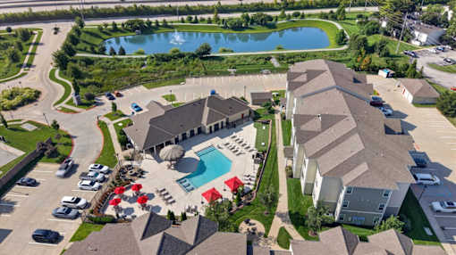 A bird's eye view of a residential area with a swimming pool and a building.