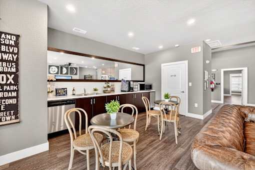 A kitchen with a dining table and chairs.