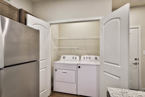 a kitchen with a washer and dryer and a refrigerator at Aventura at Hawk Ridge, Lake St Louis Missouri