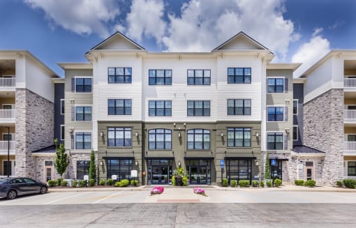 a large apartment building with cars parked in front of it at Aventura at Wild Horse Creek, Chesterfield, MO