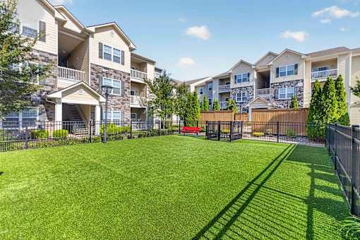 A large grassy area in front of apartment buildings.