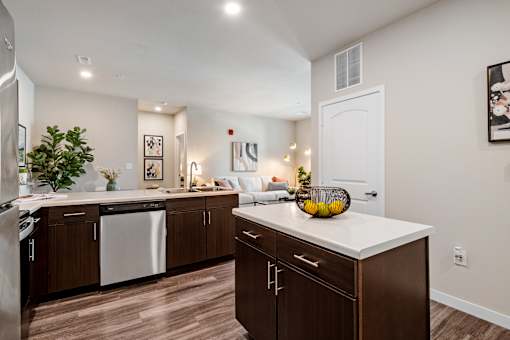 A modern kitchen with dark wood cabinets and white countertops at Aventura at Wentzville I & II Apartments, Wentzville, MO