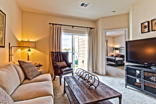 a living room with a couch and a tv  at Aventura at Mid Rivers, St. Charles, MO