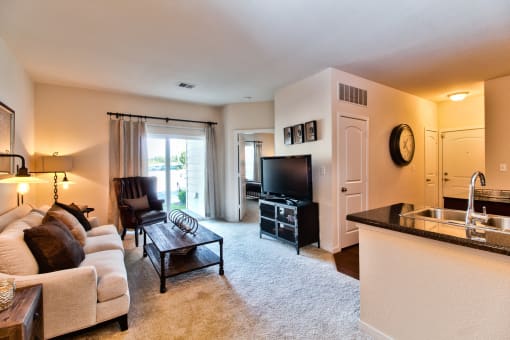 a living room with a couch and a table and a television  at Aventura at Mid Rivers, St. Charles, Missouri