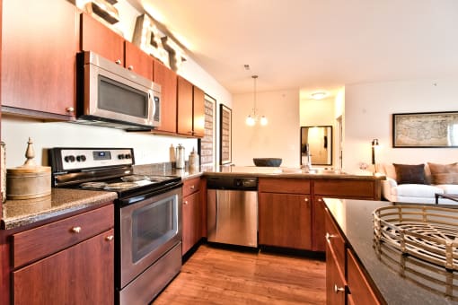 a modern kitchen with stainless steel appliances and wooden cabinets  at Aventura at Mid Rivers, St. Charles, MO