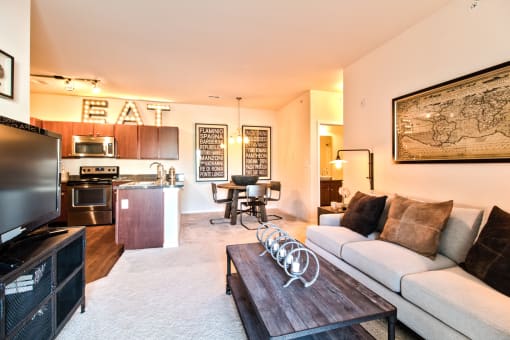 a living room and kitchen with a couch and a coffee table  at Aventura at Mid Rivers, St. Charles