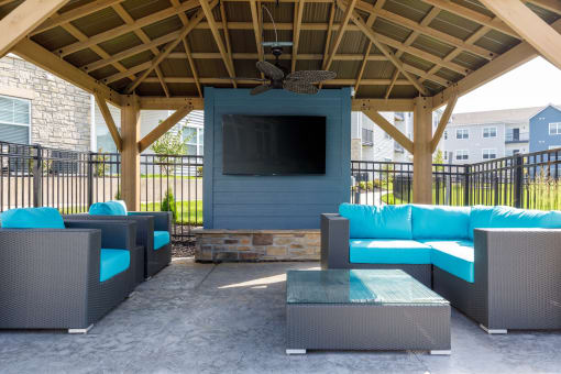 a patio with couches and a table in a pavilion with a television at The Edison at Blue Springs, Blue Springs, MO, 64014
