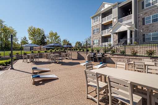 A patio area with tables and chairs in front of a building.