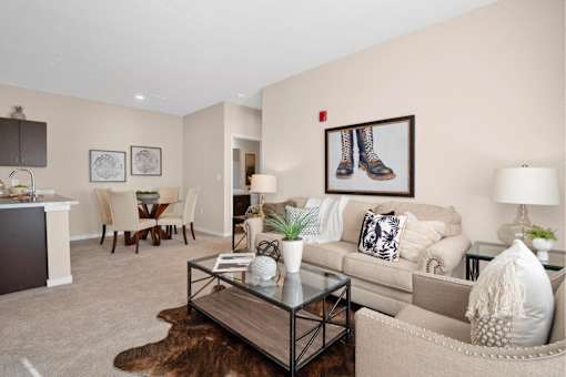 A living room with a couch, chairs, and a coffee table at Aventura at Wentzville I & II Apartments, Wentzville