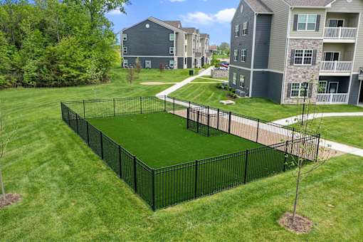 A black fence surrounds a green lawn at Aventura at Wentzville I & II Apartments, Wentzville, MO