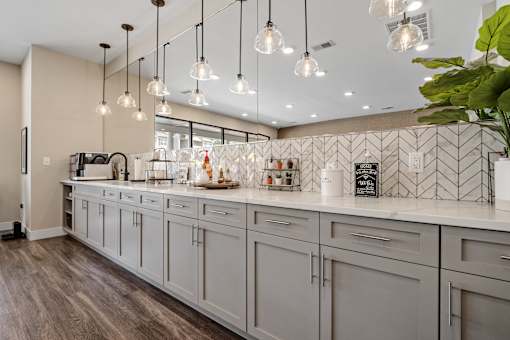 A kitchen with a white counter top and grey cabinets at Aventura at Wentzville I & II Apartments, Wentzville, Missouri