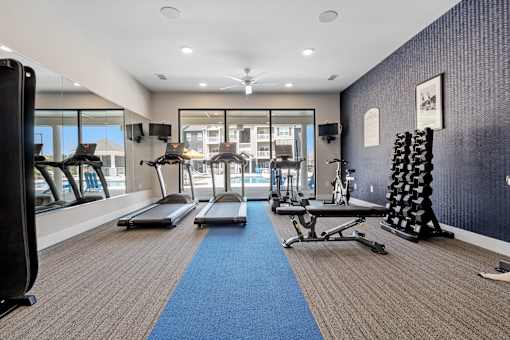 A gym with a row of treadmills and other exercise equipment at Aventura at Wentzville I & II Apartments, Wentzville, MO, 63385