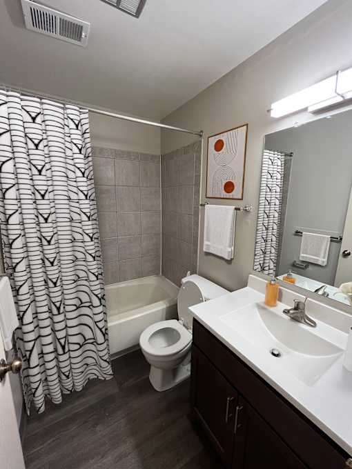 A bathroom with a toilet, sink, and shower.