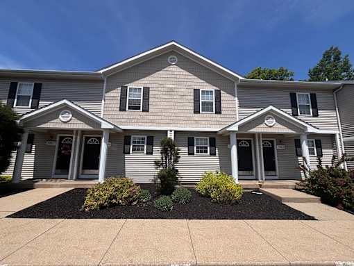 A house with a grey siding and white trim.