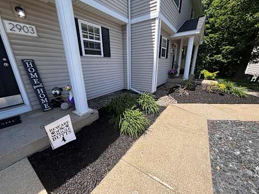 A sign on the front porch of a house warns to beware of the dog.