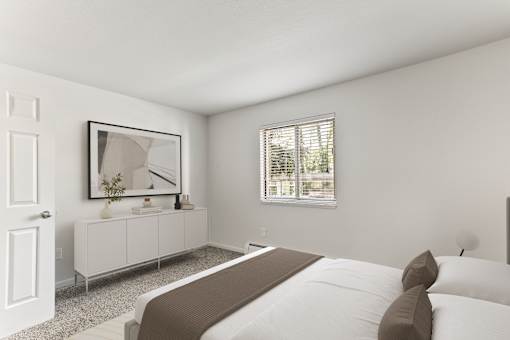 A bedroom with a large bed and a white cabinet with a mirror above it.
