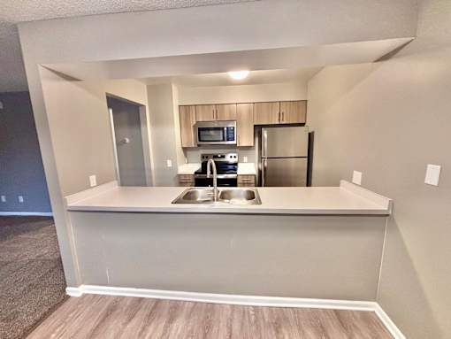 A kitchen area with a sink, stove, and refrigerator.